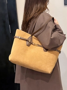 Large mustard suede tote bag with brown leather straps and gold buckle shown on shoulder