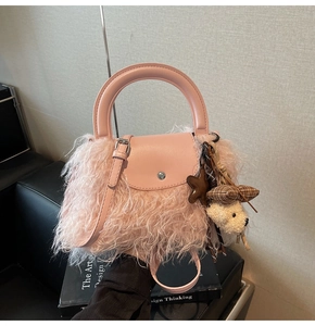 Detalle de bolso rosa de felpa con hebilla plateada y colgante de oso de peluche