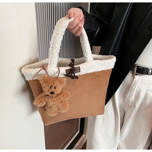 Close-up of brown suede and white faux fur tote bag with a cute plush bear charm