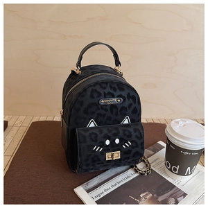 Detail of leopard print backpack with cat ear design, metal nameplate and gold chain strap