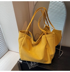 Détail d'un cabas en velours côtelé jaune montrant sa texture et son grand volume
