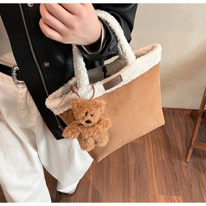Detail of suede and faux shearling tote bag with a cute brown plush bear charm