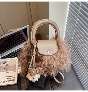 Detalle de bolso beige de piel sintética con colgante de oso y asa de cuero