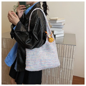 Detailed side view of rainbow crochet tote bag with a cute crochet orange charm accessory