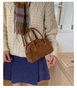 Braune Wildleder-Bowlingtasche kombiniert mit beigem Strickpullover für den Herbstlook