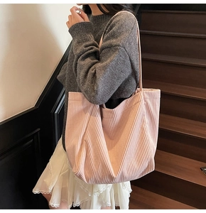 Détail de la texture en velours côtelé rose du sac cabas avec bandoulière souple
