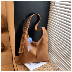 Detail of brown suede hobo bag with adjustable double buckle strap and front pocket