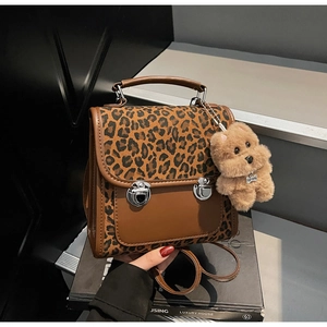 Détail du mini sac à dos à imprimé léopard et cuir avec boucles en métal et breloque ours