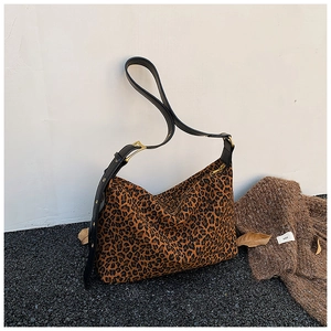 Detail of leopard print tote bag with black leather adjustable strap and gold hardware