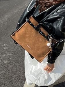 Brown suede underarm tote bag with baseball charm and Muon Shark logo detail
