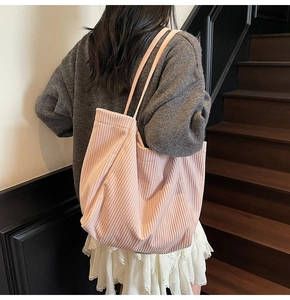 Détail rapproché de la texture velours côtelé rose d'un grand sac cabas décontracté femme