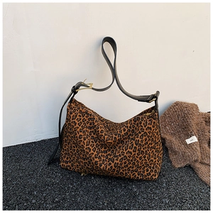 Detail of leopard print hobo bag showing large capacity and black leather strap