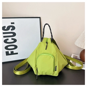 Detail of light green mini nylon backpack with braided handle and woven logo label