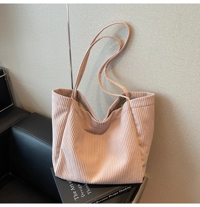 Détails de la texture en velours côtelé doux et des anses de ce sac cabas rose