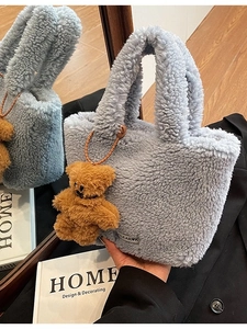 Fuzzy light blue faux lamb wool bucket bag with a cute brown bear charm and logo detail