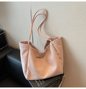 Gros plan sur le sac fourre-tout en velours côtelé rose avec texture à côtes verticales