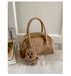 Detail of vintage brown suede Boston bag with fuzzy dog charm and sturdy top handles