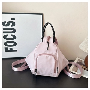 Close-up of pink mini backpack featuring a woven rope handle and sleek nylon texture