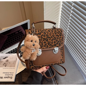 Détail du rabat léopard et sac à dos en cuir marron avec un joli porte-clés chien en peluche