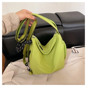 Detail of neon green waterproof nylon bag featuring adjustable strap and black zip pockets