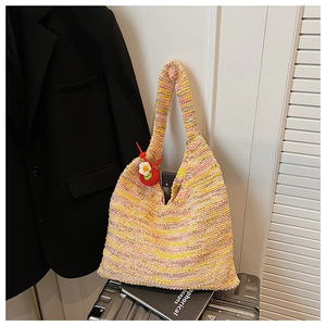 Detail of colorful rainbow woven tote bag featuring a crochet flower charm and rich texture