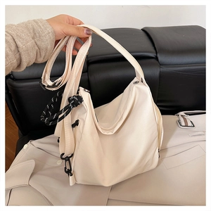 Close-up of beige waterproof nylon backpack with striped knot and matte black hardware