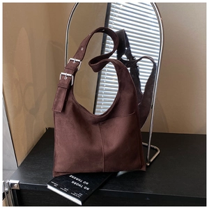 Detail of dark brown matte hobo bag with silver metal buckles on the shoulder strap