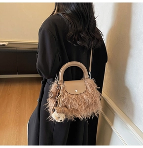 Detalle de bolso de peluche caqui con asa de cuero y colgantes de osos lindos