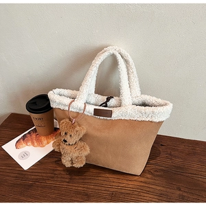 Detail of suede tote bag with fleece trim featuring a cute brown plush bear charm
