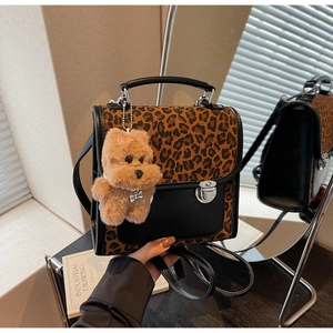Détail du sac léopard avec fermoir argenté et breloque chien en peluche sur le côté