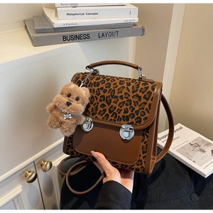 Détail du sac léopard avec rabat en cuir marron et pendentif chien en peluche Top Dog