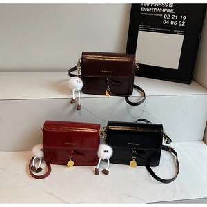 Three retro faux leather crossbody bags with glossy finish and cute plush pendants