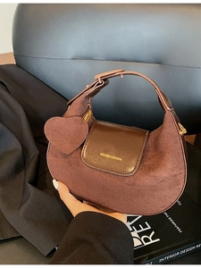 Vintage brown half-moon shoulder bag in suede leather with a decorative heart charm