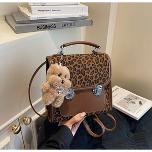 Détail du sac à dos léopard avec boucles rétro et breloque chien en peluche douce