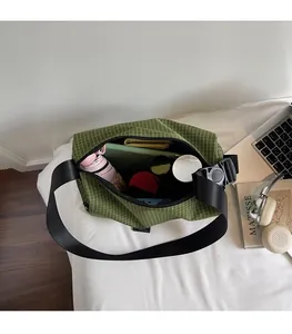 Detail view of green plaid canvas bag interior showing large capacity and items