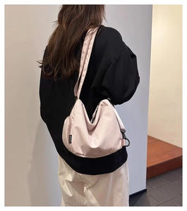 Side view of a light pink crossbody bag showing AOTUAT woven label and adjustable strap