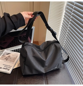 Close-up of black and grey plaid canvas crossbody bag with adjustable wide shoulder strap