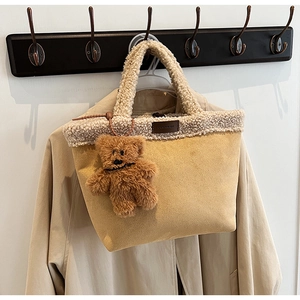 Detail of beige suede and cream faux fur tote bag with a cute brown plush bear charm