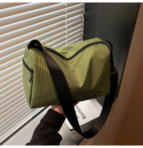Detail shot of green checkered crossbody bag with adjustable strap and side pocket