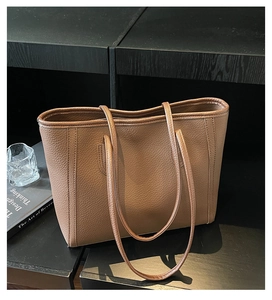 Close-up of brown litchi grain leather tote bag on a display stand for office use