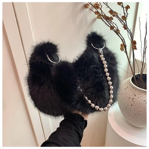Detail of plush black faux fur handbag with silver ring hardware and chunky bead chain