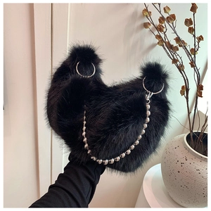 Detailed shot of black faux fur shoulder bag with silver rings and decorative bead chain