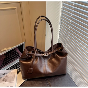 Detail of a dark brown leather tote bag with elegant metallic buckle and fine texture