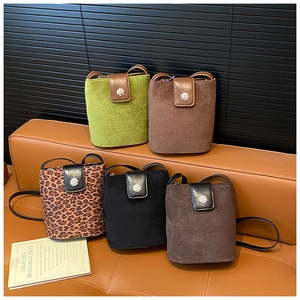 Detailed view of five vintage suede bucket bags in various colors and leopard prints