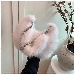 Detail of light pink faux fur crescent bag with decorative silver metal ball chain