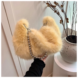 Detail of soft apricot plush dumpling bag featuring a silver bead chain strap