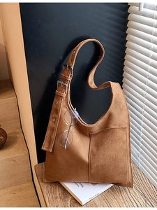 Brown suede hobo bucket bag with adjustable silver buckles and front pocket