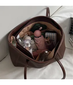 Deep brown litchi pattern leather tote bag showing spacious interior with daily essentials