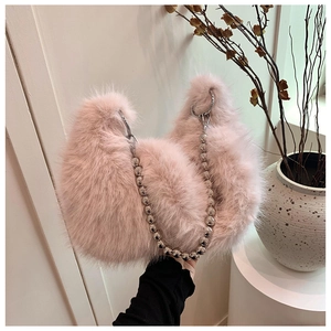 Close-up of pink fluffy plush bag with a chic silver beaded chain and soft crescent shape