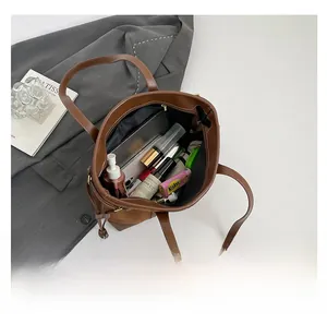 Top view of large brown tote bag showing spacious interior with tablet and cosmetics
